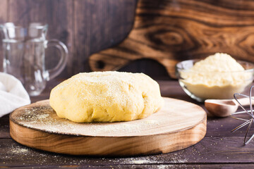 Ready raw dough for baking mexican tortillas on the board on the table. Homemade pastries