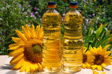 Bottles of sunflower oil on wooden table outdoors