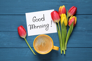 Message GOOD MORNING, tulips and coffee on blue  wooden table, flat lay