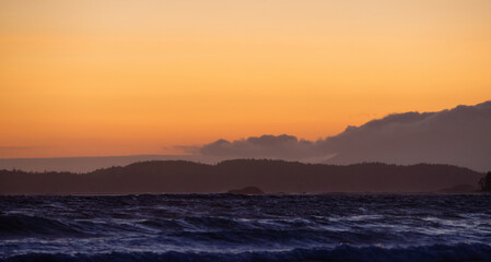 Obraz premium Waves on the Pacific Ocean on a rocky beach. West Coast. Sunny Summer Sunset. Cox Bay, Tofino, Vancouver Island, BC, Canada. Canadian Nature Background.