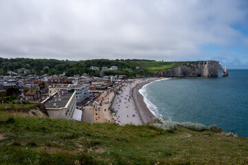 Panoramic view on chalk cliffs and Porte d'Aval arch in Etretat, Normandy, France. Tourists destination.