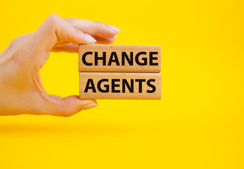 Change agents symbol. Concept word Change agents on wooden blocks. Beautiful yellow background. Businessman hand. Business and Change agents concept. Copy space