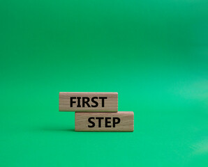 First step symbol. Wooden blocks with words 'First step'. Beautiful green background. Business and 'First step' concept. Copy space.