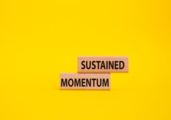 Sustained momentum symbol. Wooden blocks with words Sustained momentum. Beautiful yellow...
