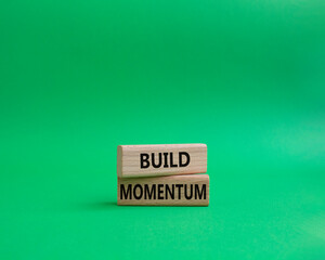 Build momentum symbol. Wooden blocks with words Build momentum. Beautiful green background. Business and Build momentum concept. Copy space.