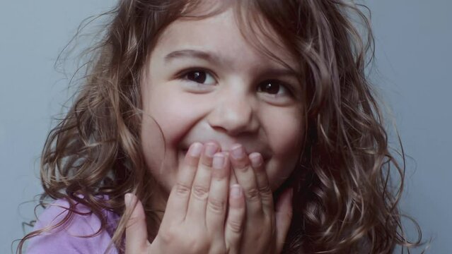 Portrait of a cute toddler girl making funny faces. 4K footage.