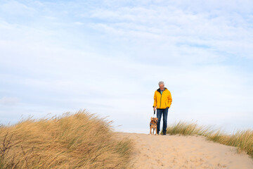 Man with dog in the Dutch dunes