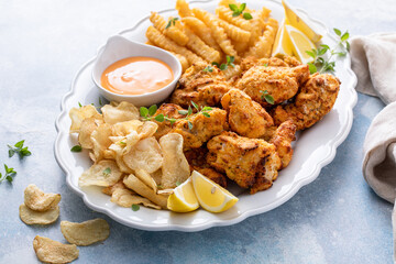 Fish and chips on a serving platter with dipping sauce