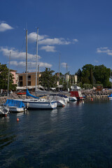 Fototapeta na wymiar Bardolino, Italy - July 11, 2022 - Cisano - the small boat harbor on a summer afternoon 