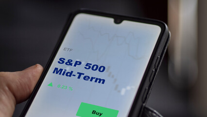 An investor's analyzing the S&P 500 mid-term etf fund on screen. A phone shows the ETF's prices sandp 500 mid term to invest