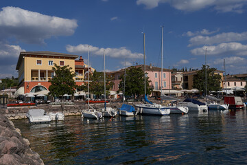 Fototapeta na wymiar Bardolino, Italy - July 11, 2022 - Cisano - the small boat harbor on a summer afternoon 