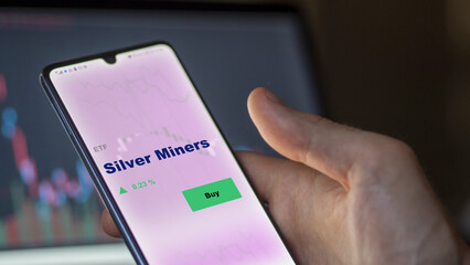 September 13th 2022, London UK. An investor's analyzing the silver miners etf fund on screen. A phone shows the silver mining ETF's prices  to invest