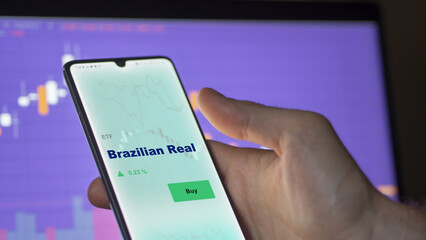 September 13th 2022, London UK. An investor's analyzing the  Brazilian Real etf fund on screen. A phone shows the currency of Brazil ETF's prices  to invest