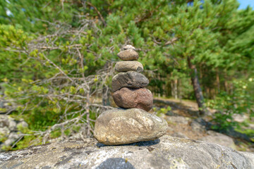 Fototapeta na wymiar Pyramid of stones. Unstable balance of stone objects. Idyllic state of nature.