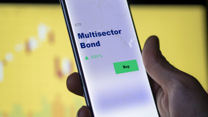 An investor's analyzing the multisector bond etf fund on screen. A phone shows the ETF's prices stocks to invest