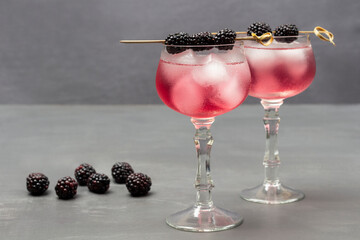 Two misted wine glasses with cooling drink and ice.