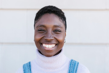 Portrait of cheerful young adult african woman smiling at camera outdoors - Happy people concept