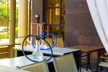 Two hookahs stand on the table in the restaurant ready for use