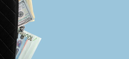 Stylish black wallet with dollars and euros on a blue background. Banner, space for text.