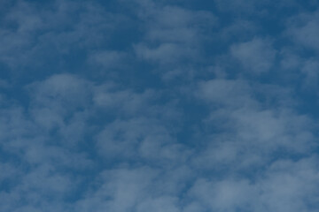 Small Puffy White Clouds in front of a Blue Sky