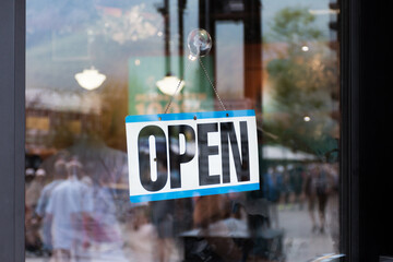 Open sign hanging in storefront window business shop closeup