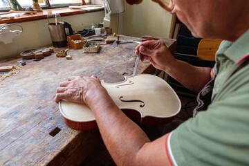 luthier carving and sculpting the f holes a violin with a knife