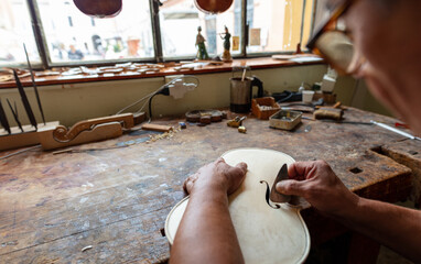 luthier carving and sculpting the f holes a violin with a knife