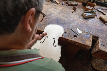 luthier carving and sculpting the f holes a violin with a knife