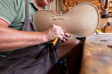 luthier carving and sculpting the f holes a violin with a knife