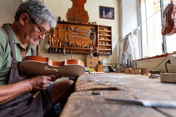 luthier carving and sculpting the f holes a violin with a knife © august.columbo