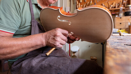 luthier carving and sculpting the f holes a violin with a knife