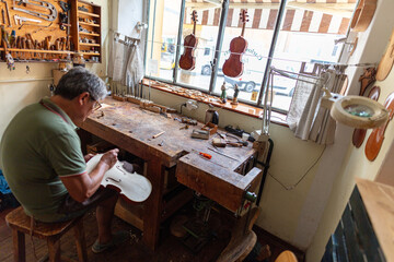 luthier carving and sculpting the f holes a violin with a knife