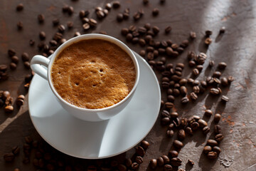 Cup of coffee cappuccino and coffee beans on the brown stone background
