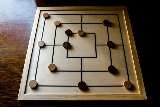 Playing mill game on a wooden table