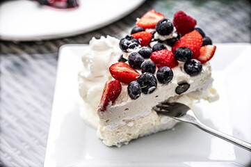 Delicious and the best dessert - Meringue with mascarpone cream and seasonal fruits strawberry and blueberry - a spectacular restaurant dessert