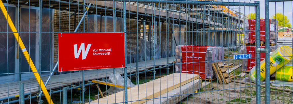 fence with van wanrooij sign in front of a house under construction, construction site in Rucphen, The Netherlands, 6 may, 2022
