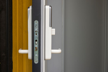 Close up view of open front door of villa with white digital lock. Sweden.