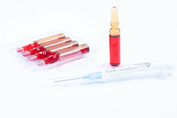 Course of injections of B vitamins. Ampoules with red liquid. Beauty and health concept