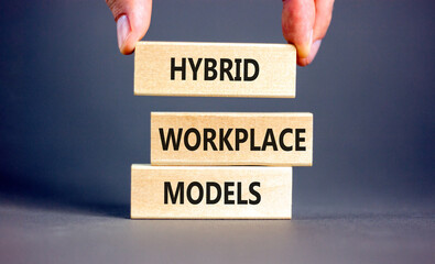 Hybrid workplace models symbol. Concept words Hybrid workplace models on wooden blocks. Businessman...
