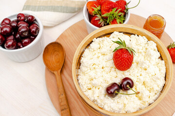 Cottage cheese with summer strawberries cherry berries.curd cheese in bowl with honey.Healthy dairy Calcium,Protein product,food breakfast,lunch,lifestyle,dieting, detox,proper nutrition.Top view