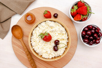 Cottage cheese with summer strawberries cherry berries.curd cheese in bowl with honey.Healthy dairy Calcium,Protein product,food breakfast,lunch,lifestyle,dieting, detox,proper nutrition.Top view