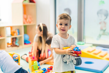 little Caucasian boy enjoying in the playroom in the kindergarten. High quality photo