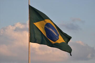 A bandeira brasileira tremulando no céu vespertino do Brasil