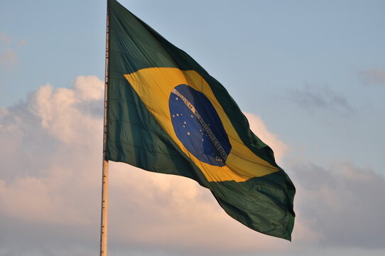 A bandeira brasileira tremulando no céu vespertino do Brasil