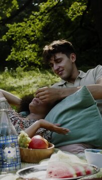 a man feeding a latino girl grapes at a picnic