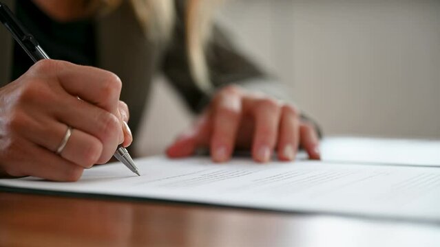 Video of a caucasian woman signing a document or contract