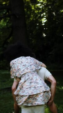 a couple playing in the park piggybacking