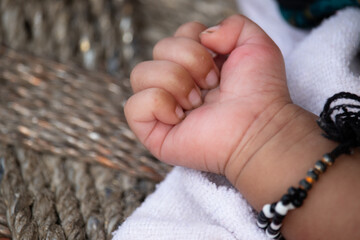 Folded Tiny Little Fingers Of Hungry One Month Or Four Weeks Old Newborn Girl With Traditional Black Beaded Bangles To Protect From Bad Luck Attention, Evil Eye, Nazar Belief In Rural Indian Tradition