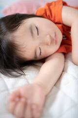 布団でお昼寝している2歳の女の子