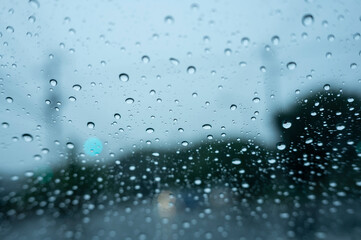 梅雨の日に車の窓ガラスについた雨粒